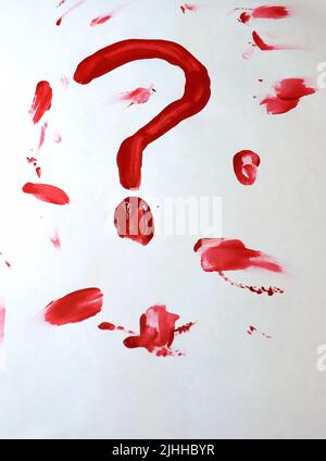 Un morceau de papier blanc vierge avec un point d'interrogation sanglant/peint dessiné entre autres frottis de sang. Le sang/la peinture est encore humide. Banque D'Images