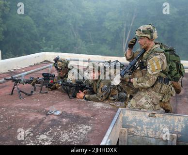 Des soldats du 2nd Bataillon, 506th infanterie, 3rd Brigade combat Team, 101st Airborne Division (Air Assault), surplombent les positions ennemies depuis un toit lors d'un exercice d'assaut de village sur fort Campbell, Ky,. 15 juillet 2022. Les soldats sont allés de pièce en pièce et de bâtiment en bâtiment pendant l'exercice pour sécuriser le village et neutraliser toute menace de la force adverse. Banque D'Images