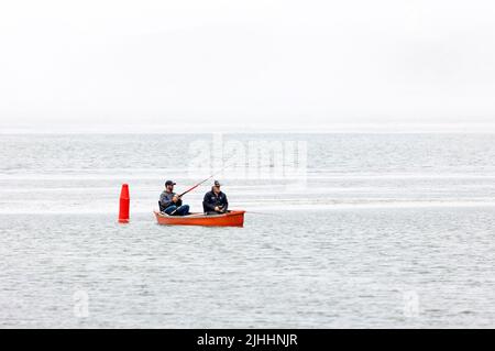 Deux pêcheurs en petit bateau rouge Banque D'Images