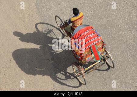 Dhaka, Bangladesh. 18th juillet 2022. Un extracteur de pousse-pousse transporte les passagers par temps chaud à Dhaka. Crédit : SOPA Images Limited/Alamy Live News Banque D'Images