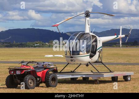 Un hélicoptère utilitaire léger Robinson R22 sur une remorque tractée par un quad Banque D'Images