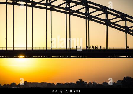 2022-07-19 06:13:16 NIJMEGEN - randonneurs pendant le lever du soleil à de Waalbrug. Le premier jour de marche des Marches de quatre jours de Nimègue 104th a été annulé en raison de la chaleur. ANP ROB ENGELAR pays-bas sortie - belgique sortie Banque D'Images