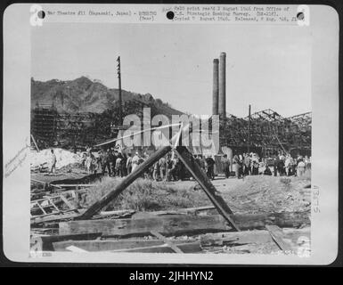 Au milieu de la destruction causée par le Blast atomique de Nagasaki, au Japon, le peuple japonais montré aligné sur cette photo, attend le train à la gare ferroviaire d'Urakami. Notez les morceaux de couverture en fer ondulé qui s'accrochent encore au bras Mitsubishi Banque D'Images