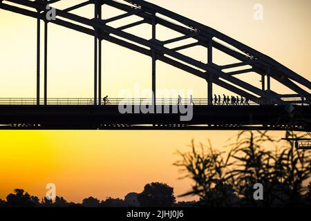 2022-07-19 06:12:57 NIJMEGEN - randonneurs pendant le lever du soleil à de Waalbrug. Le premier jour de marche des Marches de quatre jours de Nimègue 104th a été annulé en raison de la chaleur. ANP ROB ENGELAR pays-bas sortie - belgique sortie Banque D'Images