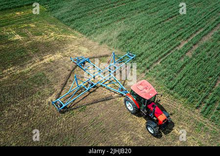 Vue aérienne de l'épandage de produits chimiques le tracteur sur le grand terrain vert Banque D'Images