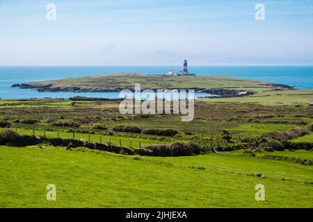 Vue sur la campagne verdoyante jusqu'au phare sur Ynys Enlli ou Bardsey Island, péninsule de Llyn, Gwynedd, nord du pays de Galles, Royaume-Uni, Grande-Bretagne Banque D'Images