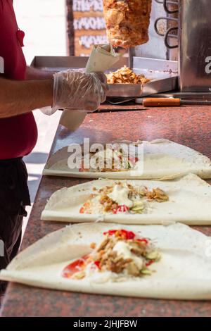 Mains d'un chef professionnel qui fabrique Shawarma dans un restaurant arabe Banque D'Images