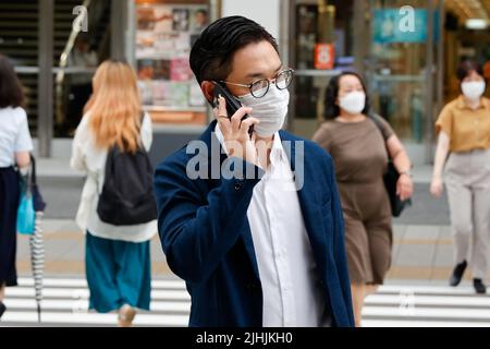 Tokyo, Japon. 19th juillet 2022. Des personnes portant des masques protecteurs pour aider à freiner la propagation du coronavirus marchent dans le centre-ville de Tokyo. Tokyo a confirmé mardi 11 018 cas de COVID-19 pour la huitième journée consécutive. (Image de crédit: © Rodrigo Reyes Marin/ZUMA Press Wire) Banque D'Images