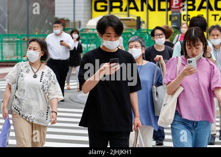 Tokyo, Japon. 19th juillet 2022. Des personnes portant des masques protecteurs pour aider à freiner la propagation du coronavirus marchent dans le centre-ville de Tokyo. Tokyo a confirmé mardi 11 018 cas de COVID-19 pour la huitième journée consécutive. (Image de crédit: © Rodrigo Reyes Marin/ZUMA Press Wire) Banque D'Images