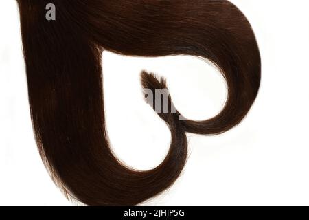 Échantillons de cheveux pour extension enroulée en forme de coeur.isolé sur blanc. Banque D'Images