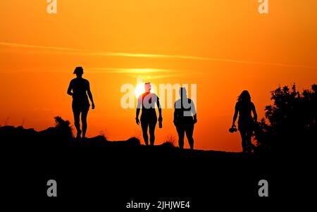 The Wrekin, Telford, Shropshire, Royaume-Uni. 19 juillet 2022. Les lève-tôt battaient la chaleur. Quatre dames qui marchent et marchent sur la colline de Wrekin à Shropshire au lever du soleil pour faire face à la montée des températures de la vague de chaleur britannique. Credit: Sam Bagnall / Alamy Live News Banque D'Images