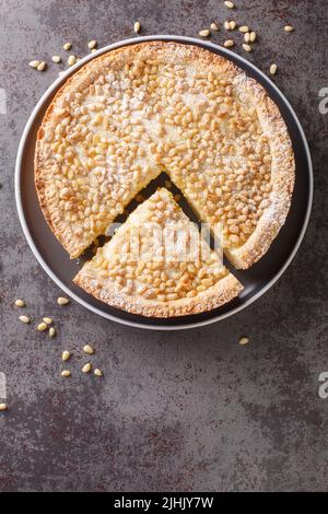 Gâteau de grand-mère italien Torta della nonna tarte aux noix de pin de Toscane dans l'assiette sur la table. Vue verticale du dessus Banque D'Images