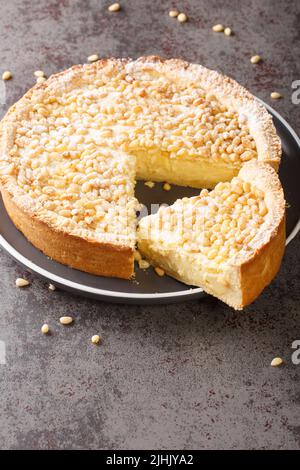 Gâteau de grand-mère italien Torta della nonna tarte aux noix de pin de Toscane dans l'assiette sur la table. Verticale Banque D'Images