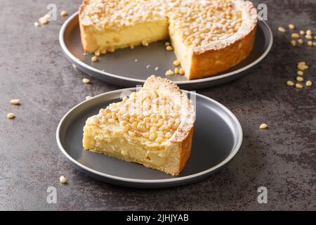 Morceau de tarte grand-mère italienne avec crème anglaise et pignons dans une assiette sur la table. Horizontale Banque D'Images