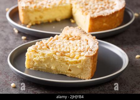 Gâteau italien recouvert de pignons de pin connu sous le nom de torta della nonna closeup dans l'assiette sur la table. Horizontale Banque D'Images