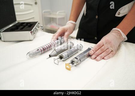 Un médecin gynécologue préparant des instruments et un laser pour les procédures d'antivieillissement des femmes patients Banque D'Images