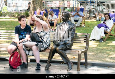 Les gens sont assis à l'ombre à Leicester Square, dans le centre de Londres, alors que les Britanniques sont sur le point de connaître la journée britannique la plus chaude jamais enregistrée, alors que les températures devraient atteindre 40C. Date de la photo: Mardi 19 juillet 2022. Banque D'Images