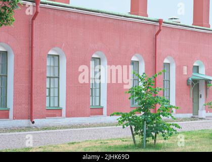 vieux bâtiment en brique rouge avec de grandes fenêtres et un passe de promenade. maison de campagne utilisée pour faire une ferme. Banque D'Images