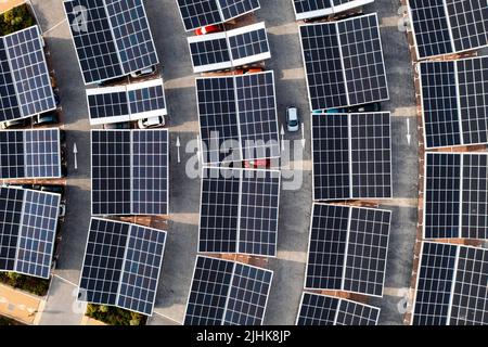 Vue aérienne directement au-dessus des voitures électriques parking sous panneaux solaires sur un toit de stationnement prêt pour la charge Banque D'Images