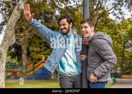 Latino gay couple s'amuser dans un parc Banque D'Images