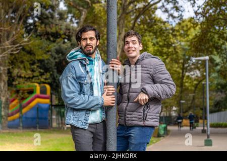 Latino gay couple s'amuser dans un parc Banque D'Images