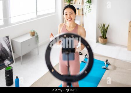 Jeunes souriants médias sociaux asiatique influent enregistrement vidéo pour le blog fitness Banque D'Images