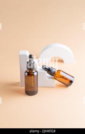 Flacons compte-gouttes avec maquettes de produits cosmétiques sur podiums géométriques en béton. Contexte pour la présentation de cosmétiques. Banque D'Images