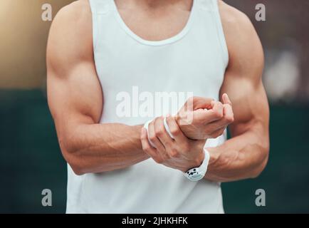 Un joueur de tennis de course mixte inconnu souffrant de blessures au poignet dans un jeu de court. Hispanique FIT professionnel dans la douleur tout en tenant et frottant la main après Banque D'Images