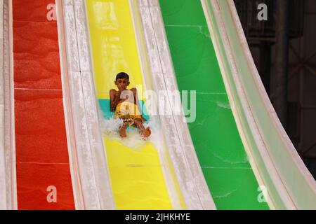 Bagdad, Irak. 19th juillet 2022. Un garçon irakien descend sur un toboggan aquatique dans un parc aquatique au milieu d'une vague de chaleur en Irak. L'Irak connaît une vague de chaleur avec des températures qui atteignent plus de 45 degrés Celsius. Credit: Ameer Al-Mohammadawi/dpa/Alamy Live News Banque D'Images