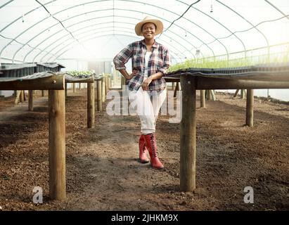 Plein corps de jeune agriculteur dans un jardin. Portrait d'un fier agriculteur dans sa serre. Bon agriculteur afro-américain. Jeune agriculteur debout en elle Banque D'Images