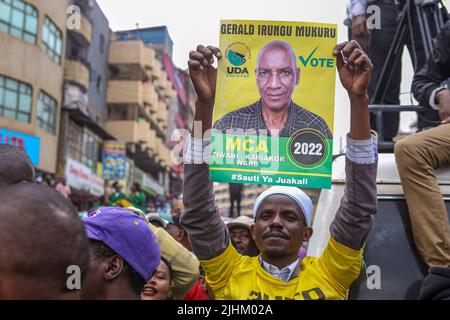 Un Kenyan est titulaire d'une affiche de l'un des membres de l'Assemblée du comté (MCA), qui se présente au poste électif lors d'un rassemblement de campagne du vice-président du Kenya et du candidat présidentiel de l'Alliance démocratique unie (UDA) William Ruto sur le marché de Gikomba à Nairobi. William Ruto est tireur pour la présidence sur un billet de l'Alliance démocratique unie (UDA) avant les élections générales du 9th août 2022 au Kenya. Il affrontera 3 autres candidats parmi lesquels l'ancien Premier ministre du Kenya et le candidat à la présidence d'Azimio la Umoja, Raila Odinga. Ruto a visité le marché de Gikomba Banque D'Images