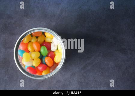 Vue de dessus de jelly haricots dans un bol sur noir Banque D'Images