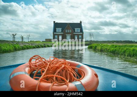 LISSE, PAYS-BAS - 22 avril 2017: Maison sur la rive de la rivière. Vue depuis le bateau de voyage dans le parc de fleurs de Keukenhof. Mise au point sélective. Concept de vie simple. Banque D'Images