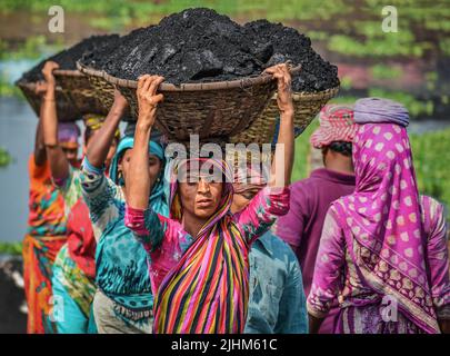 Les travailleuses transportant des paniers remplis de charbon sur leur tête dans la région de Gabtoli à Dhaka Banque D'Images