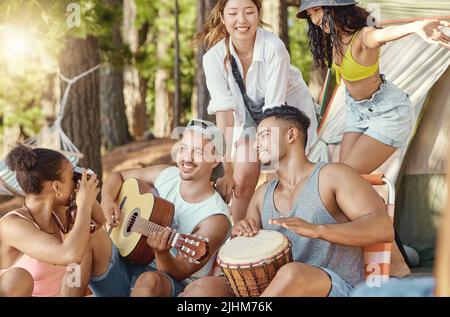 N'ont pas manqué un seul moment ensemble. Un groupe diversifié d'amis assis et de liaison pendant une journée dans les bois. Banque D'Images