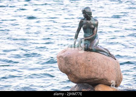 Statue de bronze ou sculpture de la petite Sirène exposée sur un rocher au bord de l'eau à la promenade Langelinie à Copenhague, Danemark Banque D'Images