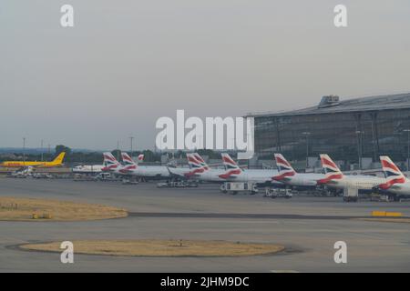 Au terminal 5 de l'aéroport d'Heathrow, les avions British Airways sont alignés aux portes. Comme les écoles d'État sont sur le point de commencer leurs vacances d'été, des pressions vont s'exercer sur les aéroports, car les familles commencent leurs vacances et de nombreux vols ont déjà été annulés en raison de la pénurie de personnel au sol et de manutentionnaires de bagages à Heathrow et dans d'autres aéroports. Anna Watson/Alamy Banque D'Images