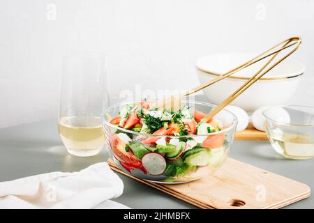 Salade de légumes avec tomates, concombre, radis dans un bol en verre. Banque D'Images