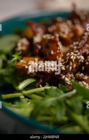 salade chaude aux champignons, graines de sésame et gros plan sur l'arugula. macro. Banque D'Images