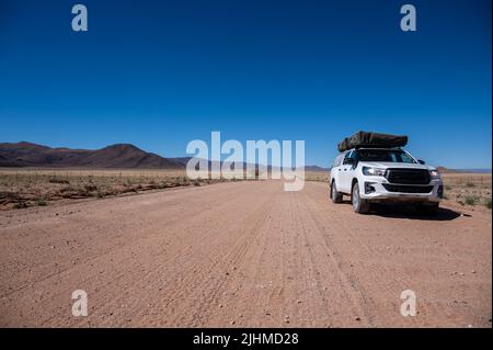 Un 4x4 sur une route de gravier en Namibie Afrique Banque D'Images