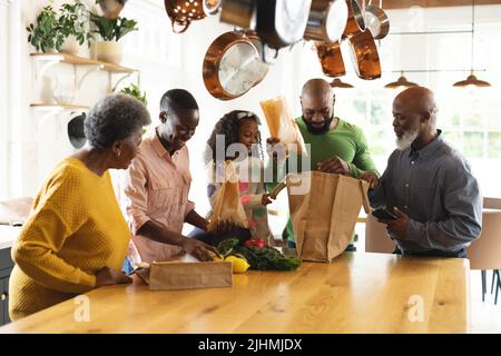 Image de la famille africaine américaine multi-génération de déballage des sacs de shopping Banque D'Images