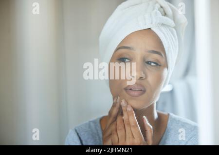 C'est parti. Une jeune femme a fait un bouton sur son visage à la maison. Banque D'Images