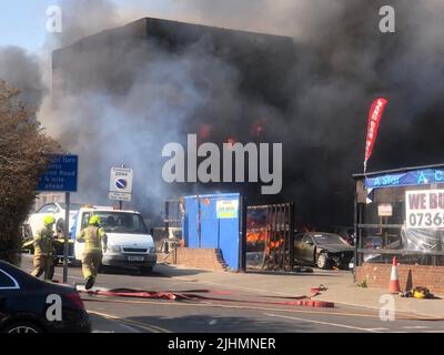 Photo de distribution prise avec la permission du fil Twitter de @VekariaDipak d'un magasin de lavage de voiture et de pneus dans les flammes sur Kenton Road. Date de la photo: Mardi 19 juillet 2022. Banque D'Images