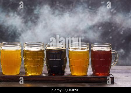 Ensemble de dégustation de différents types de bière sur une table sur fond de grunge avec espace de copie Banque D'Images