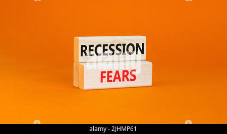 Symbole de la peur de la récession. Mots-clés la récession craint sur des blocs de bois sur un beau fond orange de table. Les entreprises et la récession craignent con Banque D'Images