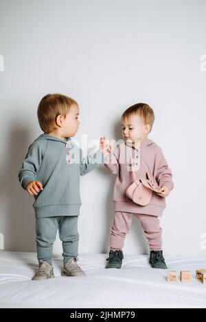 Mode bébé. Vêtements unisexes pour bébés. Ensemble en coton pour deux jeunes filles ou garçons Banque D'Images