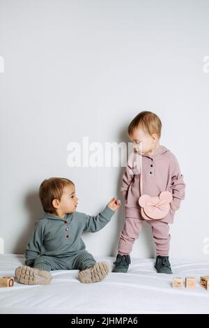 Mode bébé. Vêtements unisexes pour bébés. Ensemble en coton pour deux jeunes filles ou garçons Banque D'Images