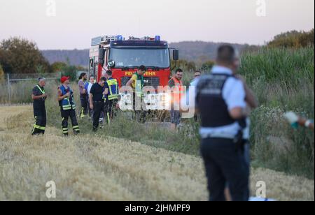 Mengen, Allemagne. 19th juillet 2022. Les pompiers, la police et les ambulanciers se tiennent près d'un champ de maïs où se trouve un gyrocoptère écrasé. Le pilote a été tué dans l'accident. Selon un porte-parole du quartier général de la police de Ravensburg, le soi-disant « gyrocopter » s'est écrasé au sol à environ 150 mètres lors d'un atterrissage raté, mardi soir. Credit: Thomas Warnack/dpa/Alay Live News Banque D'Images