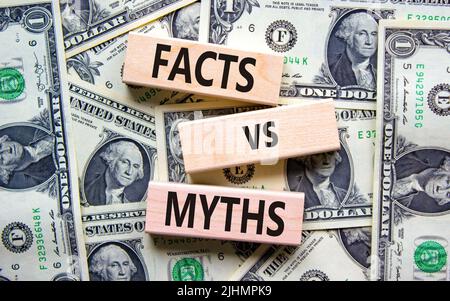 Symbole des faits et des mythes. Concept mots faits vs mythes sur des blocs de bois sur un beau fond de billets de dollar. Affaires, finacial et faits vs mythe Banque D'Images