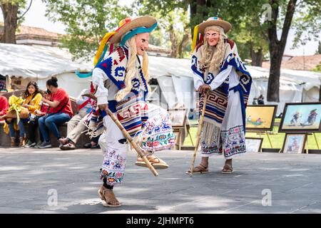 Les jeunes garçons mexicains, vêtus du costume traditionnel de vieil homme, exécutent le Danza de los Viejitos traditionnel à la place de la ville de la Plaza Vasco de Quiroga, 11 avril 2022 à Patzcuaro, Michoacan, Mexique. Banque D'Images